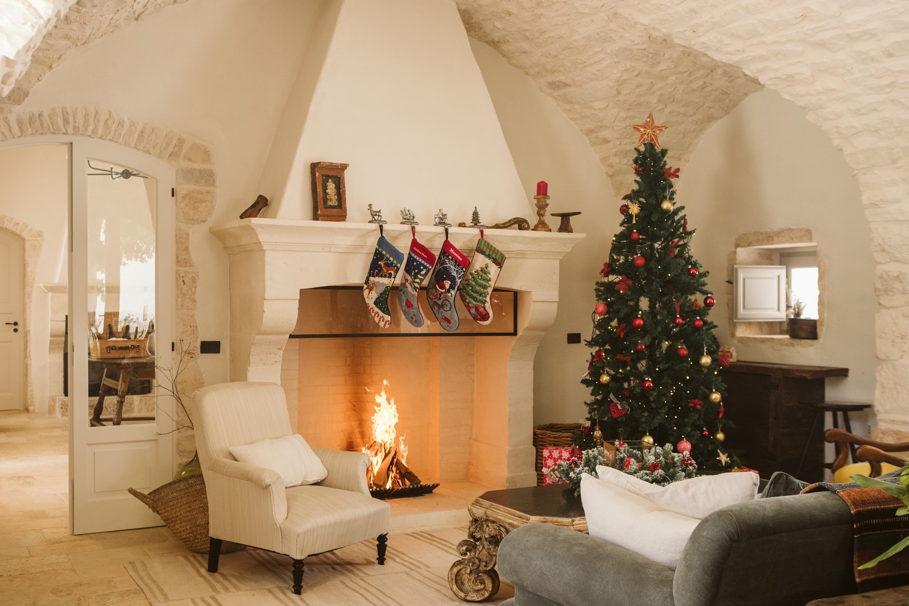 Christmas tree and stockings beside the lit fireplace at Masseria Pistola